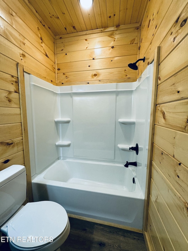 bathroom featuring wooden walls, wooden ceiling, shower / bathtub combination, and toilet