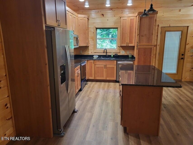 kitchen with pendant lighting, sink, a center island, stainless steel appliances, and light wood-type flooring