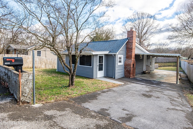 view of front of house featuring a carport and a front yard