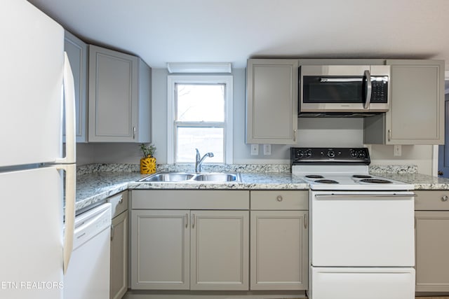 kitchen featuring sink, gray cabinetry, and white appliances