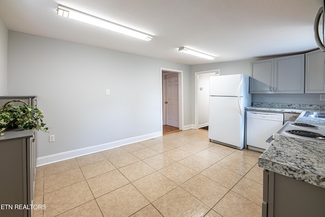 kitchen featuring white appliances, gray cabinets, a textured ceiling, and light tile patterned flooring