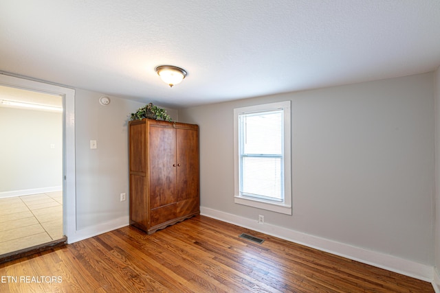 unfurnished bedroom featuring hardwood / wood-style flooring and a textured ceiling