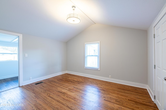 additional living space with lofted ceiling and hardwood / wood-style flooring