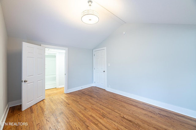 interior space featuring lofted ceiling, hardwood / wood-style flooring, and a closet