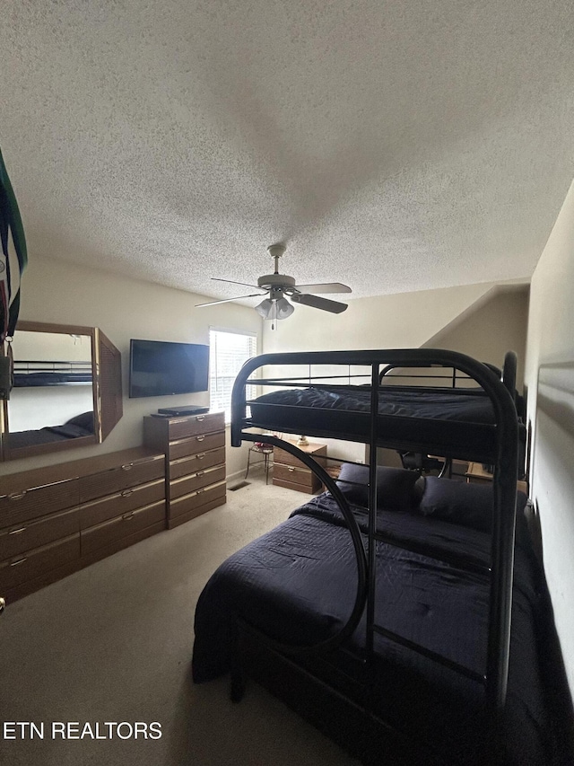 bedroom featuring ceiling fan, carpet flooring, and a textured ceiling