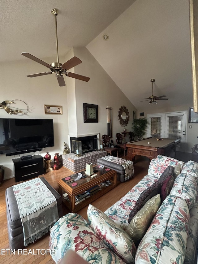 living room featuring pool table, high vaulted ceiling, hardwood / wood-style flooring, ceiling fan, and a fireplace