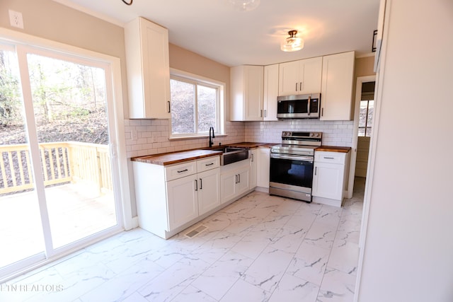 kitchen featuring white cabinetry, sink, tasteful backsplash, and stainless steel appliances