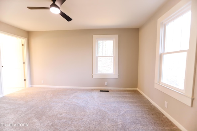 unfurnished room featuring carpet, a wealth of natural light, and ceiling fan