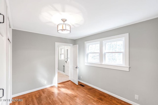 unfurnished bedroom with ornamental molding and light hardwood / wood-style flooring