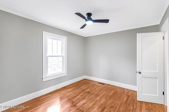 spare room with ornamental molding, ceiling fan, and light wood-type flooring