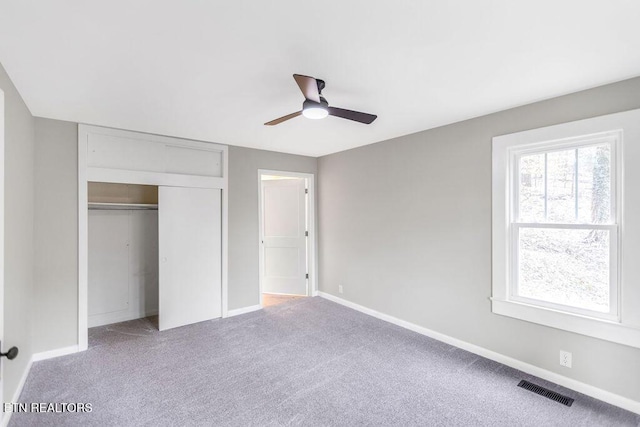 unfurnished bedroom with light carpet, ceiling fan, and a closet