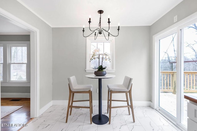 dining space featuring crown molding and a chandelier