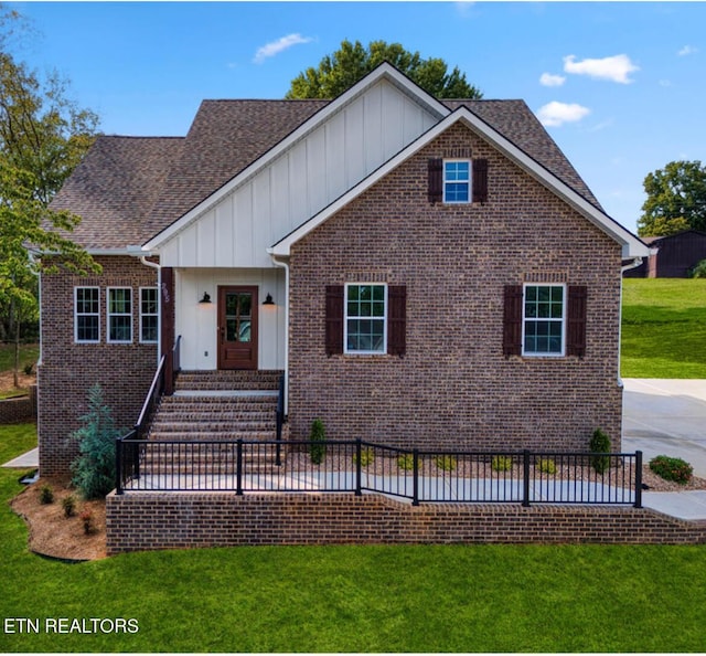 295 Caulderwood Ln, Lenoir City, TN 37771 - view of front of home featuring board and batten siding, brick siding, and a front yard
