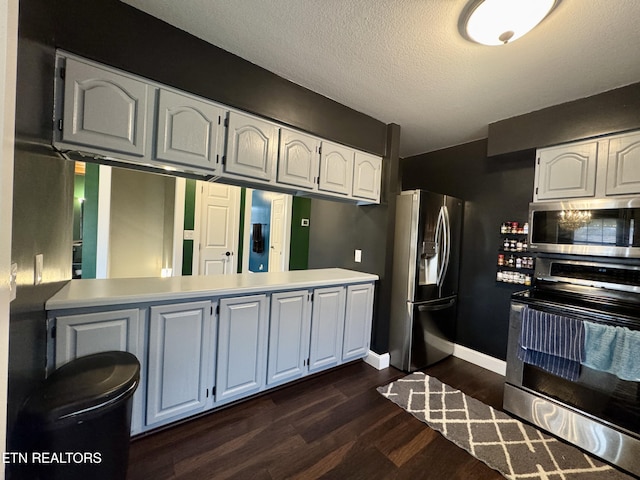 kitchen featuring dark hardwood / wood-style floors, stainless steel appliances, kitchen peninsula, and white cabinets