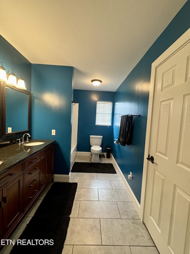 bathroom with tile patterned flooring, vanity, toilet, and a textured ceiling