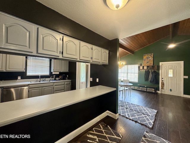 kitchen with sink, white cabinetry, lofted ceiling with beams, dark hardwood / wood-style flooring, and dishwasher