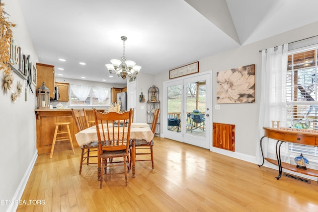 dining room with light hardwood / wood-style flooring and a notable chandelier