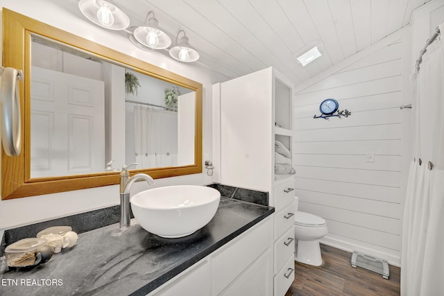 bathroom with toilet, wood walls, wood ceiling, vaulted ceiling, and hardwood / wood-style floors