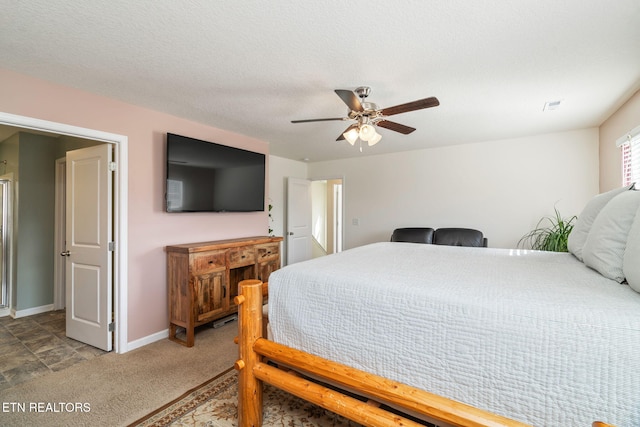 bedroom with ceiling fan, carpet flooring, and a textured ceiling