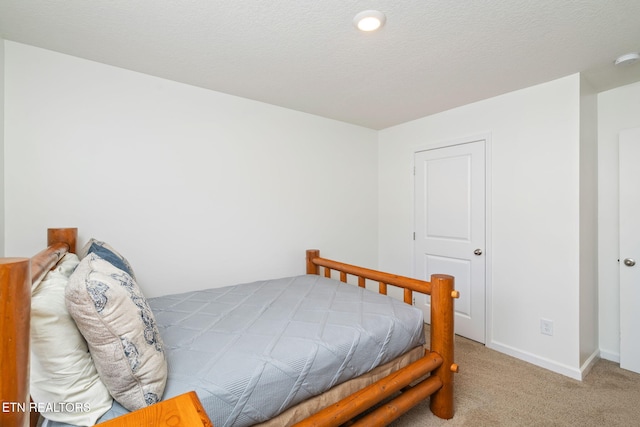 bedroom featuring a textured ceiling and carpet