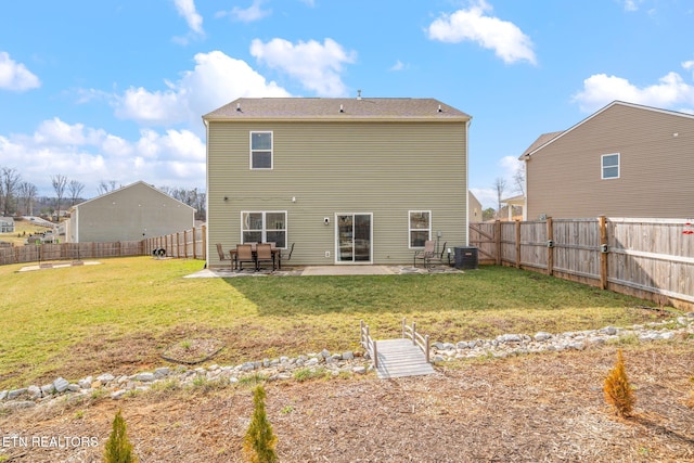 back of house featuring central air condition unit, a patio area, and a lawn