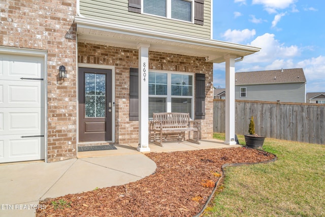 doorway to property with a porch and a garage