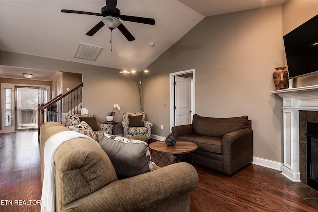 living room featuring ceiling fan, dark hardwood / wood-style floors, high vaulted ceiling, and a tile fireplace