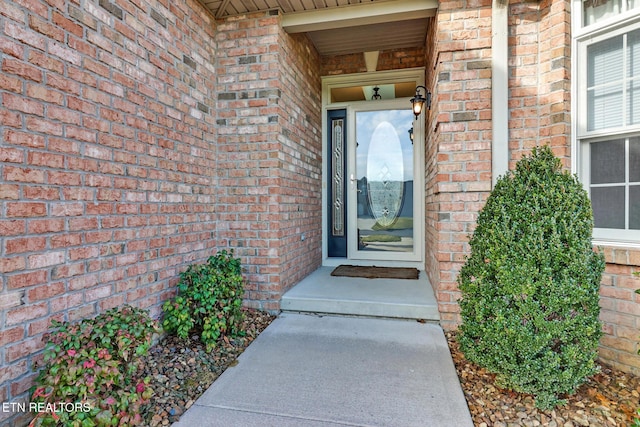 view of exterior entry featuring brick siding