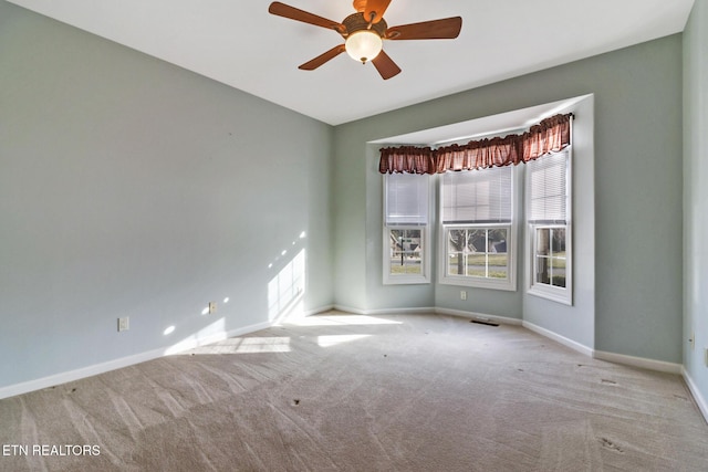 carpeted spare room with baseboards and ceiling fan