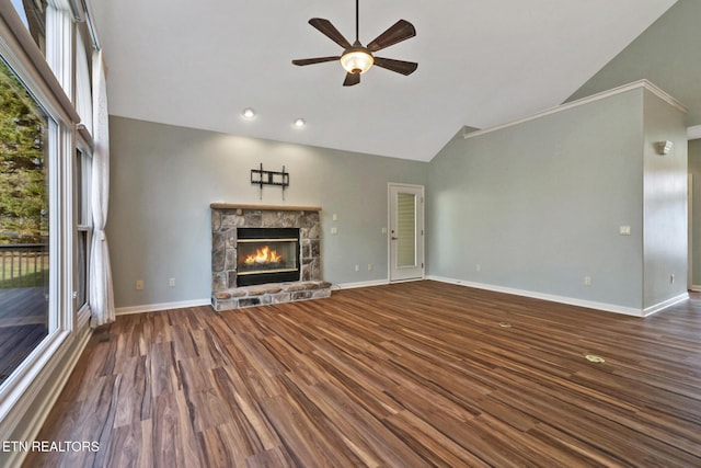 unfurnished living room with high vaulted ceiling, wood finished floors, a stone fireplace, baseboards, and ceiling fan