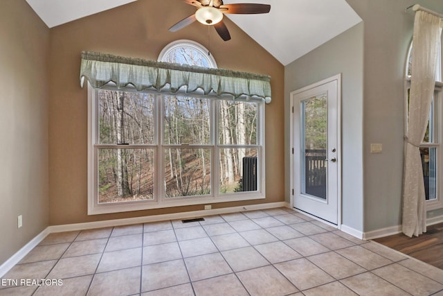 interior space with lofted ceiling, light tile patterned flooring, and visible vents