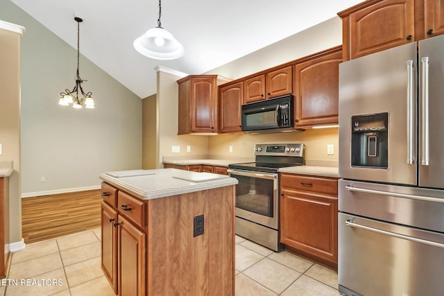 kitchen featuring light tile patterned flooring, a center island, stainless steel appliances, and light countertops