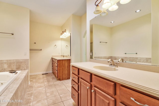 full bath with a sink, two vanities, a bath, and tile patterned flooring