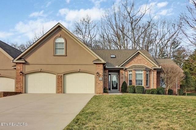 view of front of property featuring stucco siding, driveway, a front yard, a garage, and brick siding