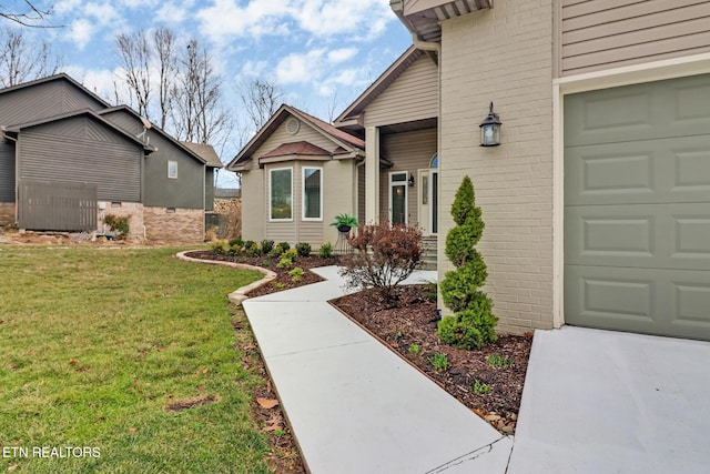 property entrance featuring a yard and a garage