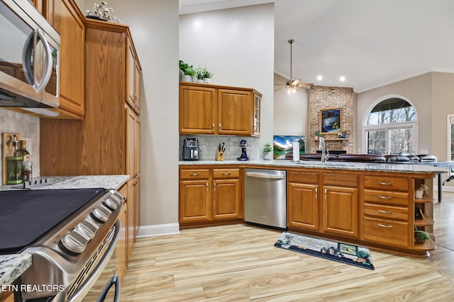 kitchen with stainless steel appliances, ceiling fan, sink, and light wood-type flooring