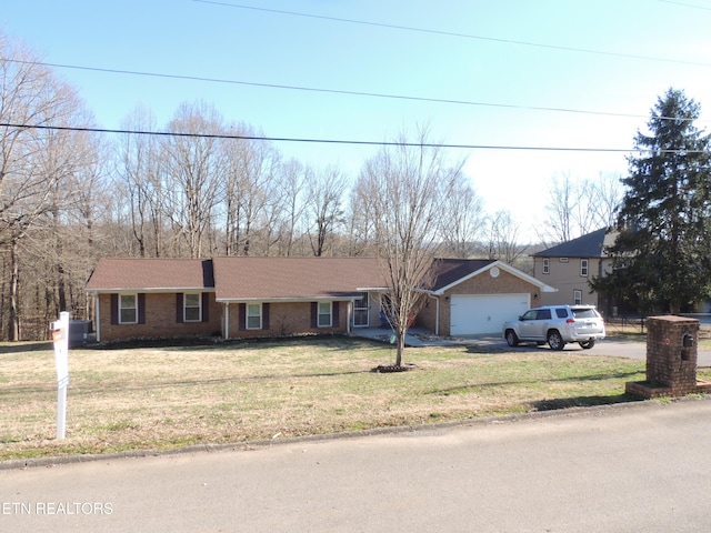 single story home featuring a garage and a front lawn