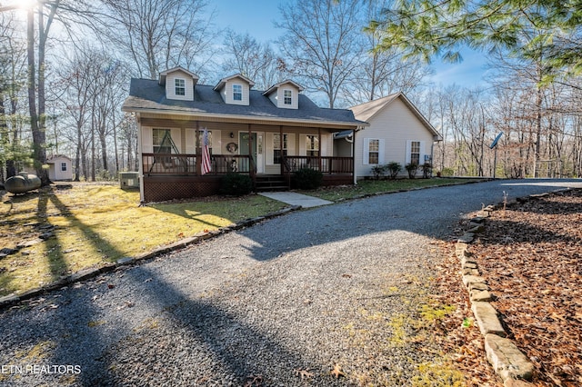 cape cod-style house with a front lawn and covered porch