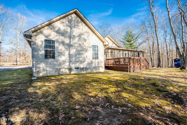 view of side of home with a wooden deck and a lawn