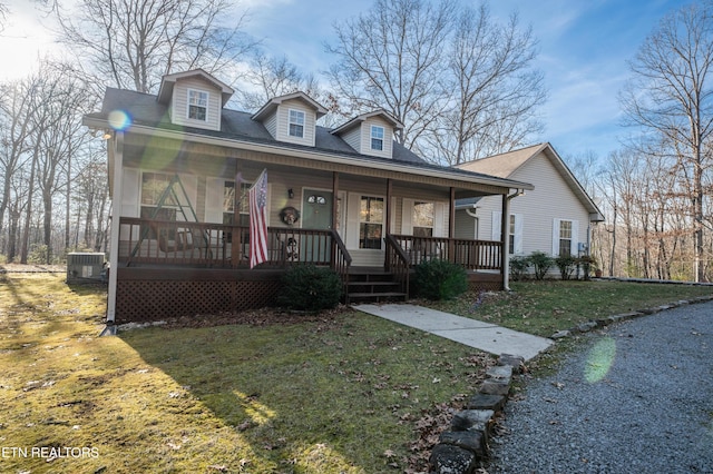 bungalow-style house featuring a porch, a front yard, and central air condition unit