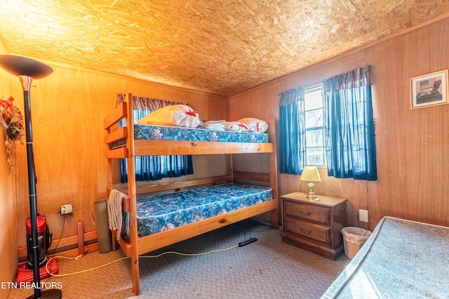 bedroom with carpet floors and wood walls