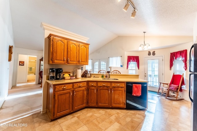 kitchen with decorative light fixtures, vaulted ceiling, a textured ceiling, dishwasher, and a notable chandelier