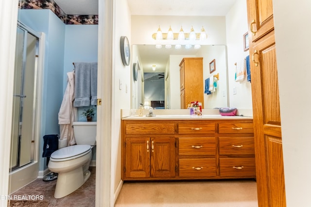 bathroom featuring vanity, tile patterned floors, a shower with door, and toilet