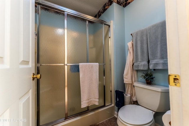 bathroom with toilet and an enclosed shower