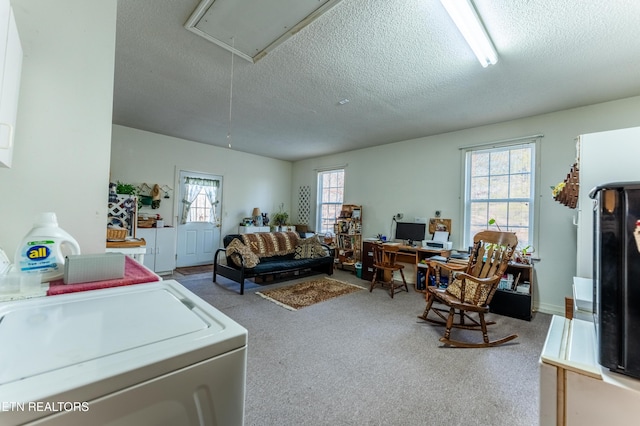 living room with washing machine and dryer, carpet flooring, and a textured ceiling