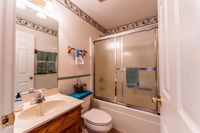 full bathroom with vanity, bath / shower combo with glass door, toilet, and a textured ceiling