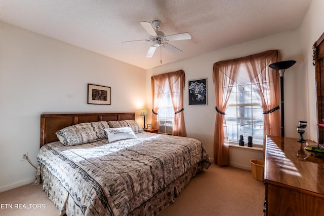 carpeted bedroom featuring ceiling fan and a textured ceiling