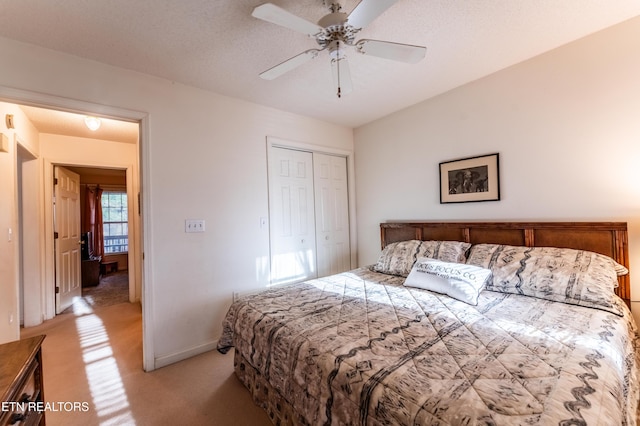 carpeted bedroom featuring a textured ceiling, a closet, and ceiling fan