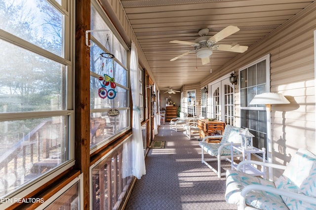 unfurnished sunroom with ceiling fan