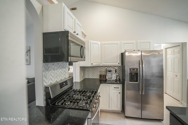 kitchen with white cabinetry, backsplash, high vaulted ceiling, and appliances with stainless steel finishes